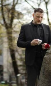 Przez przyciemnione szkło krematorium Ethan dostrzegł delikatne drżenie pod białym materiałem okrywającym ciało jego żony.