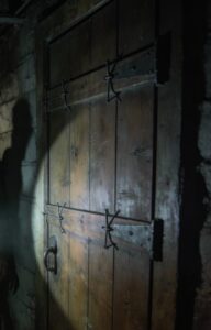 Przeprowadziliśmy się do starego domu moich dziadków, żeby zrobić remont. Sprzątając piwnicę, odkryłem drzwi zabite deskami. Zawołałem ojca, żeby zajrzał. Natychmiast zbladł i krzyknął: „NIE OTWIERAJ!”. Zapytałem go dlaczego… a on wybuchnął płaczem. „Bo twoja siostra wciąż tam jest”.